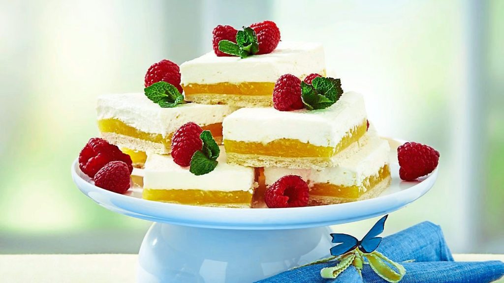 Lemon Cheesecake Bars sits next to some berries (Easy desserts with few ingredients)
