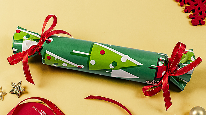 DIY noisemakers made by filling a halved paper towel tube with rice, taping the ends shut, then covering in wrapping paper and cinching the ends with ribbon
