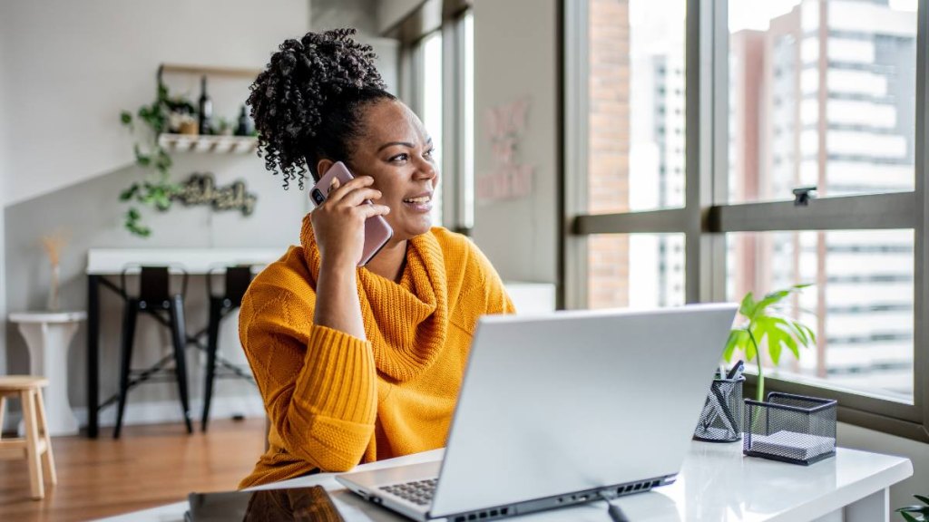 How to make money as a stay at home mom: Black woman talking on the phone at home