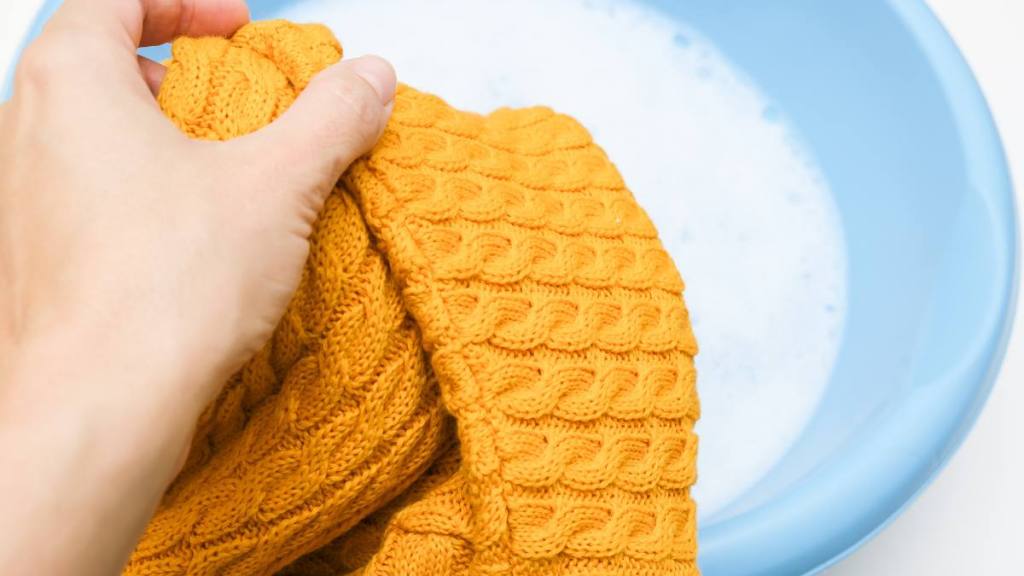 How to Unshrink a Sweater: Hand washing of delicate woolen knitted clothes, sweaters concept, care of bright color clothes