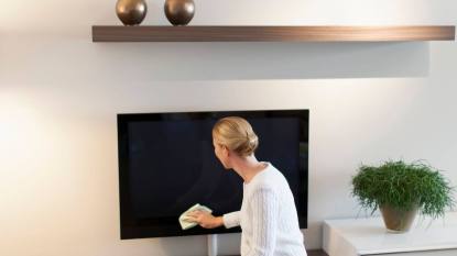 How to clean a TV screen: Woman cleaning house,