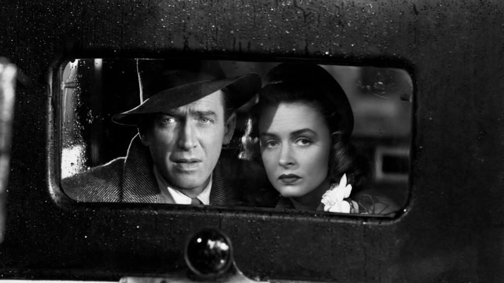 Jimmy Stewart and Donna Reed looking through back car window in “It’s a Wonderful Life”