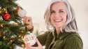 Christmas aesthetic: Portrait of Caucasian woman hanging ornaments on Christmas tree