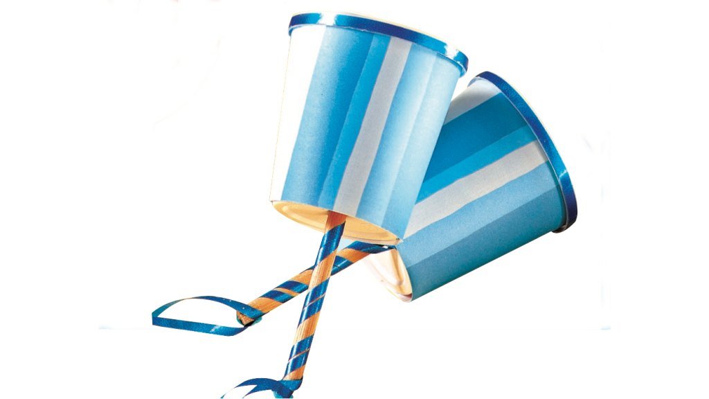 DIY noisemakers made by gluing a wooden craft stick to the bottom of a paper-wrapped yogurt cup, filling with dried beans, then taping the top of cup shut and covering with a circle of paper