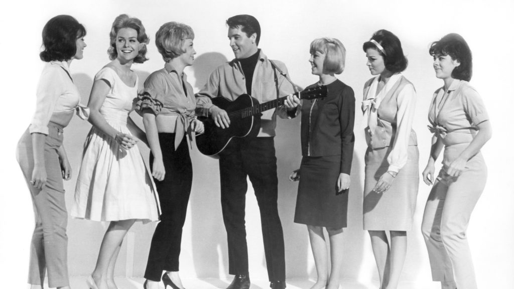 Elvis Presley surrounded by actresses Joan Freeman, Sue Ane Langdon and Raquel Welch (second right) on the set of Roustabout, 1964