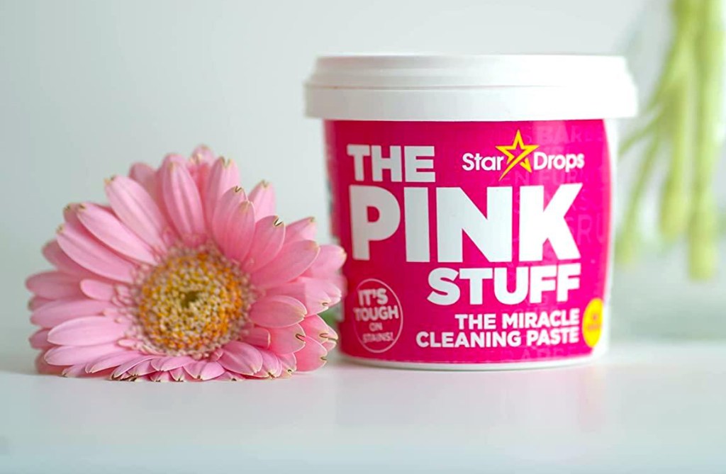 How to use The Pink Stuff: Cleaning Paste in Tub shown on tabletop next to pink flower