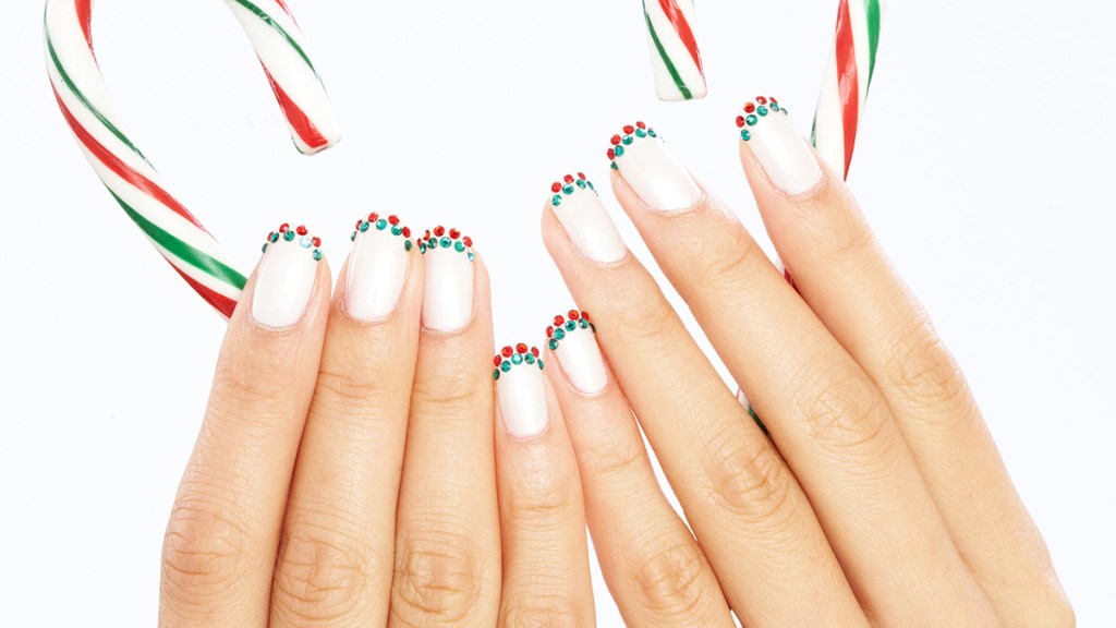 Nails painted while with red and green rhinestone-accented tips