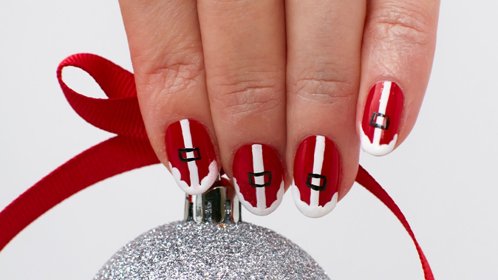 Nails painted with a Santa suit design