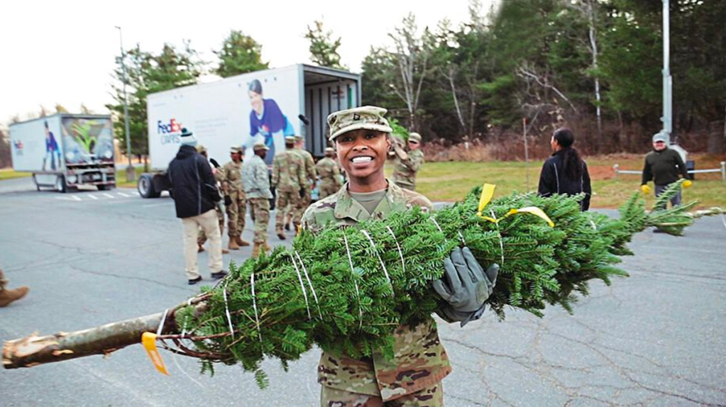 Soldier smiling while holding tree