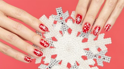 Nails painted with a snowflake design, one of the holiday nail ideas