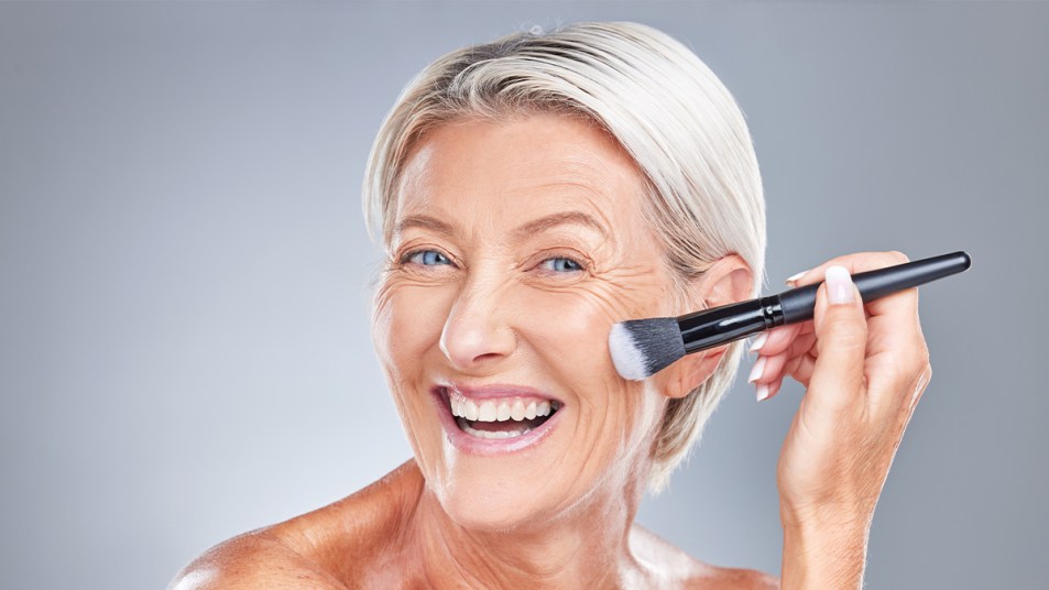 mature woman conturing her face with a makeup brush