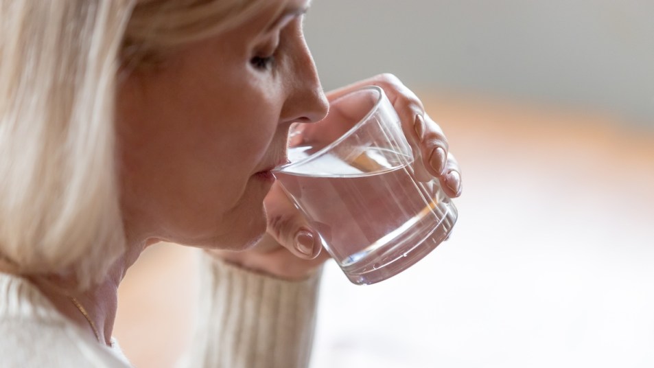 Woman in profile drinking glass of water