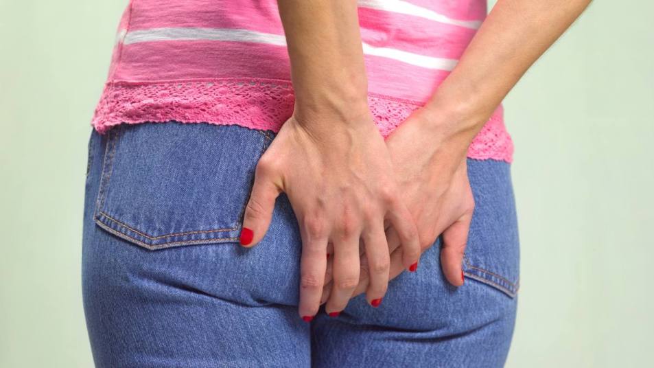 do hemorrhoids itch: WOMAN CLUTCHING BOTTOM WITH PROBLEMS