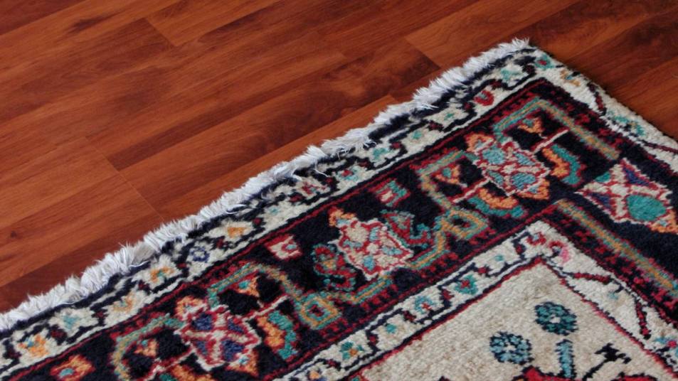 How to flatten a rug: Corner of oriental rug on hardwood floor