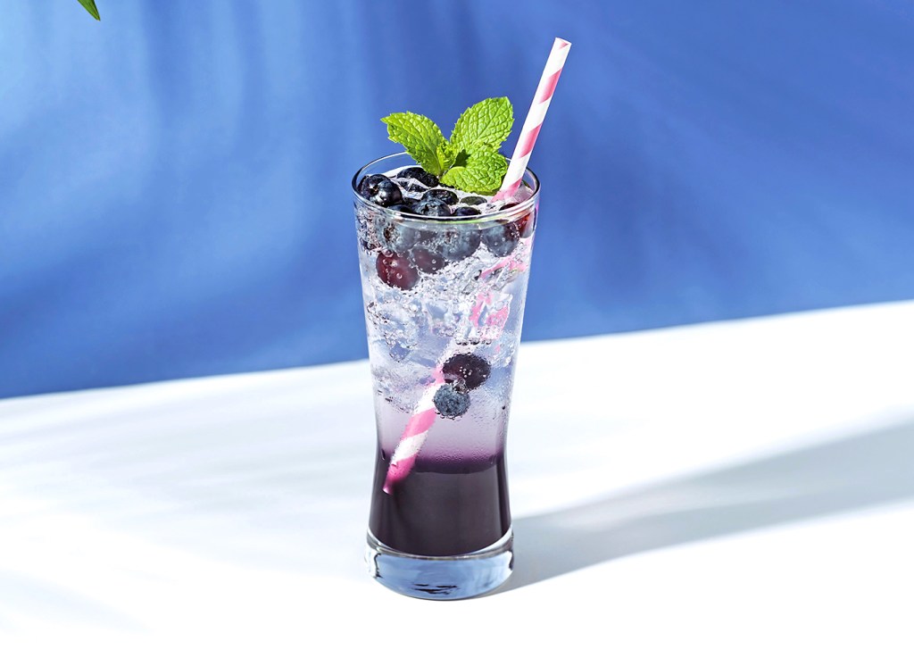 Paint and sip party: Refreshing blueberry punch cocktail with mint on purple background