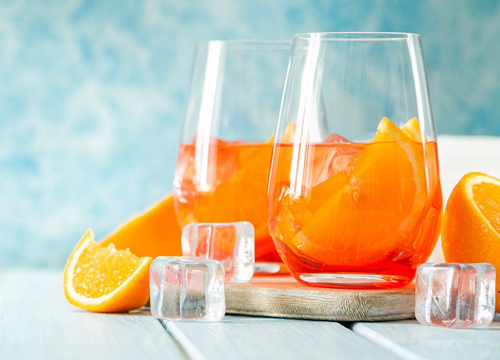 Pizza party: Aperol and ingredients drinks on wood background