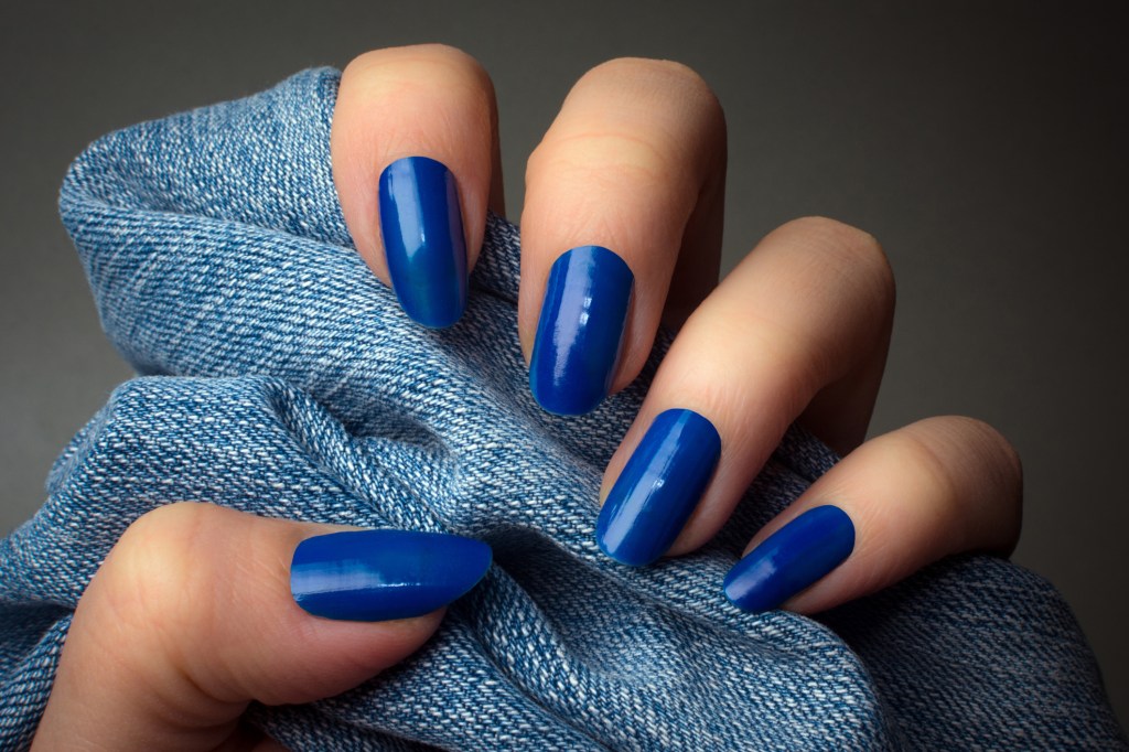 Close up of bold blue nails holding blue scarf