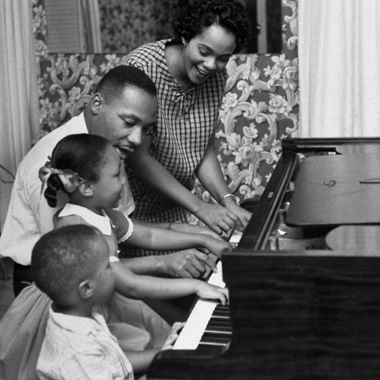 Civil Rights activist Rev Dr. Martin Luther King Jr. and his wife Coretta, daughter Yolanda, 5, and Martin Luther III, 3, sitting together as they play piano
