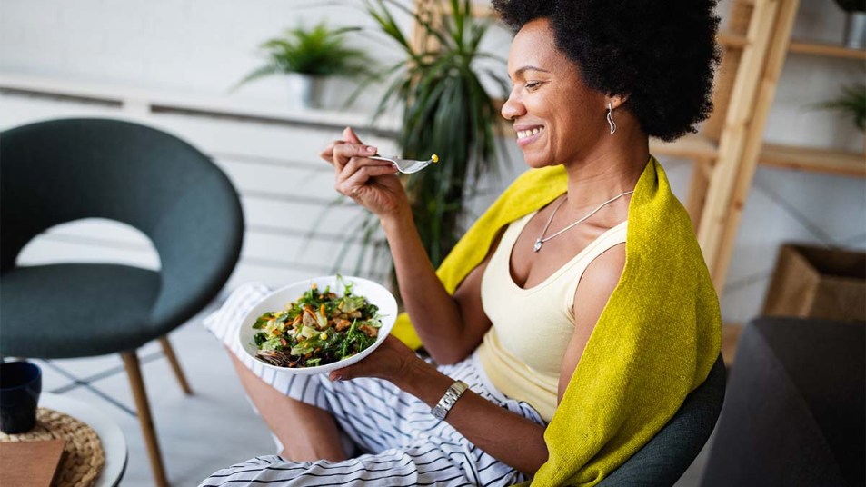Woman eating a vegetable salad at home