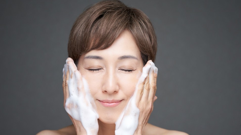 Middle-aged Japanese woman washing face with foam