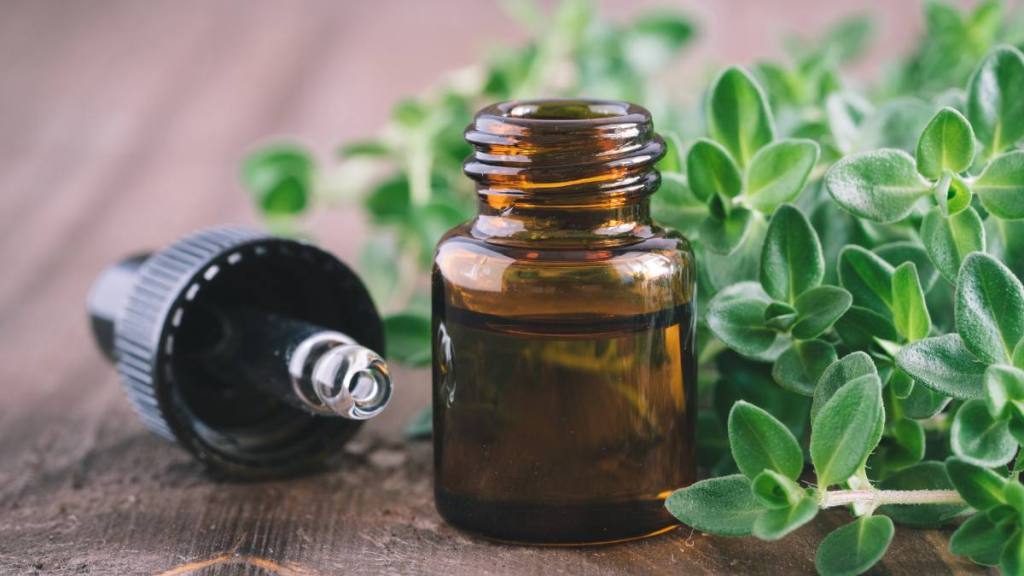 An essential oil, which helps stop bleeding gums, next to greenery