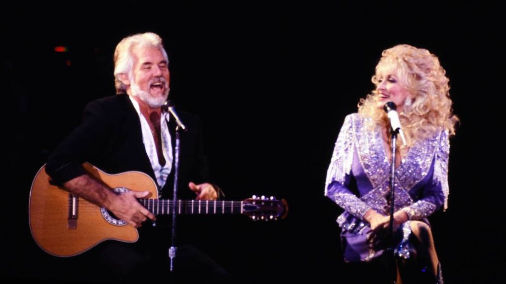 Man and woman singing on stage; Kenny Roger songs