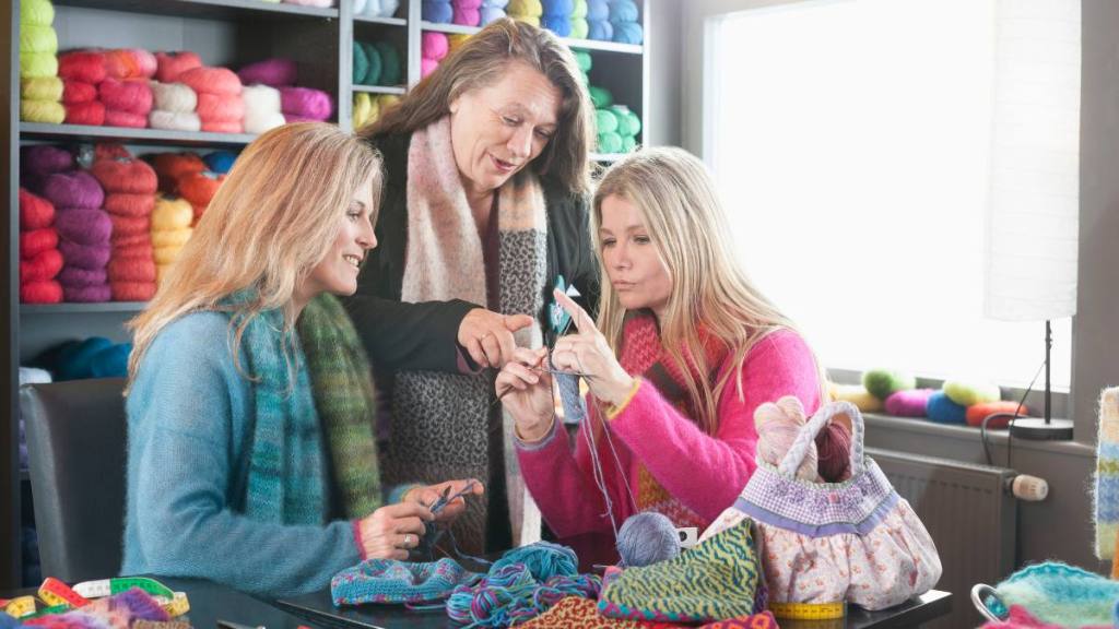Knitting teacher with two women in knitting lesson
