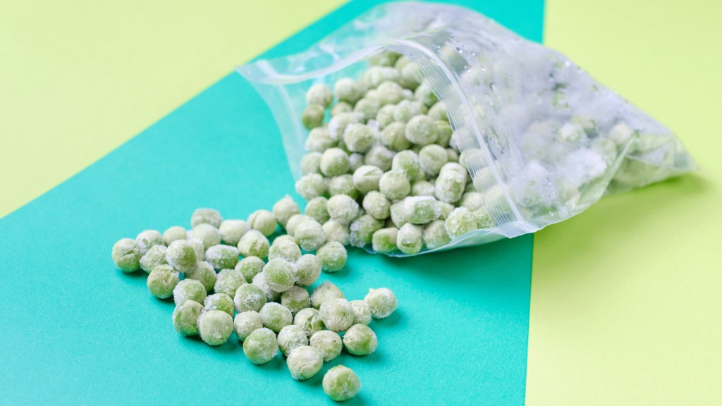 A bag of frozen peas, which can be used for arthritis self-care, scattered on a colorful background