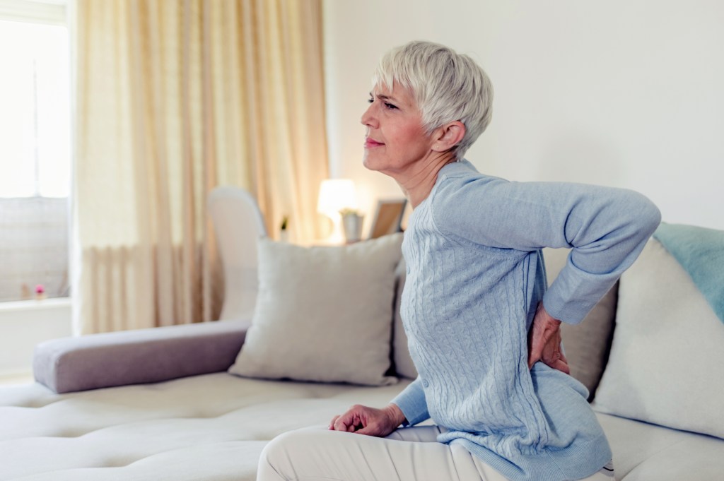 mature woman feeling back because of back pain