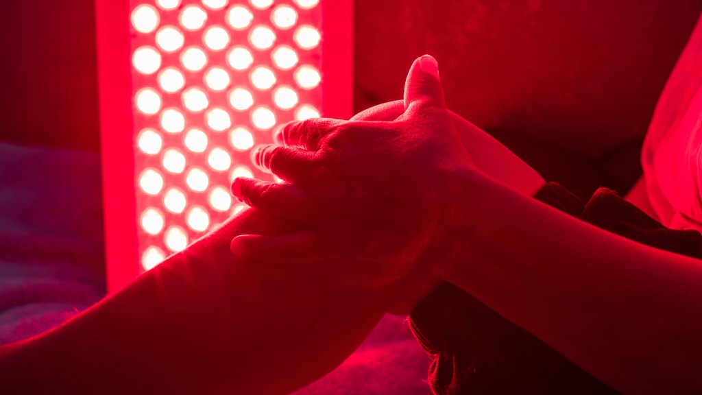 Closeup of sore leg of a person treating with the red light therapy panel