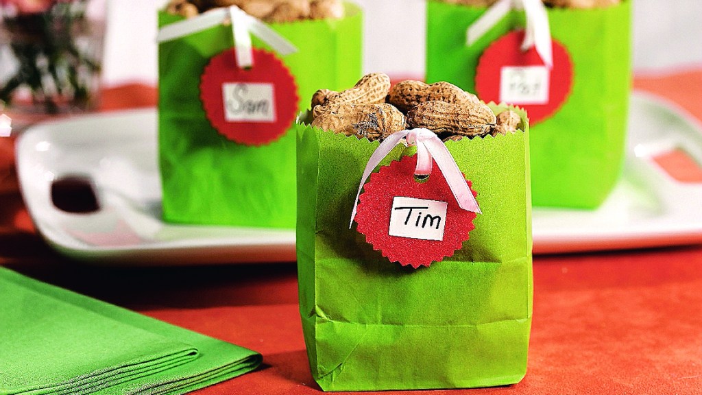 DIY football decorations: Individual green paper snack bags filled with roasted in-shell peanuts and adorned with personalized name tags