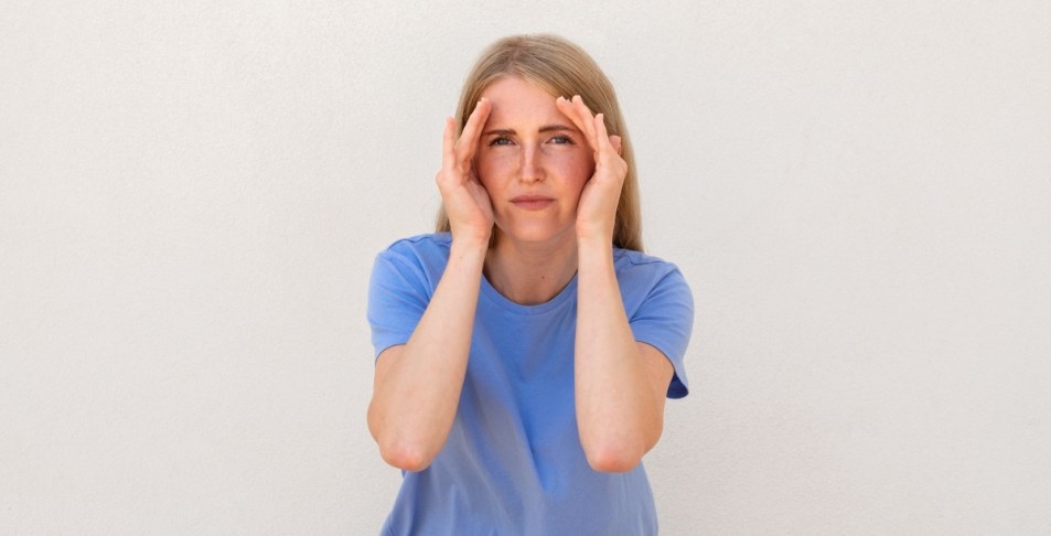 Woman trying to concentrate by blocking out the sides of her face with her hands