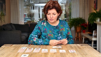 Woman playing solitaire at table