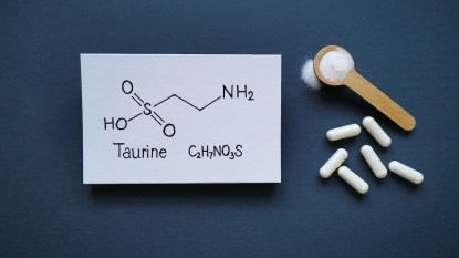 Taurine supplemet pills and powder with graphic showing taurine's chemical formula