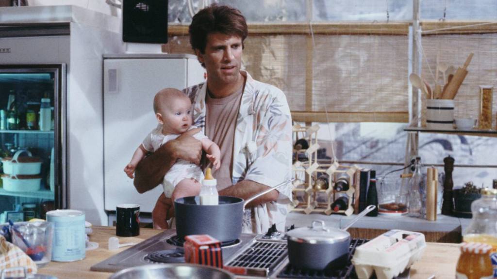 Man holding a baby in the kitchen