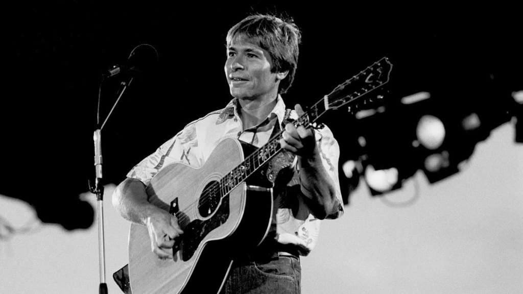 John Denver playing guitar