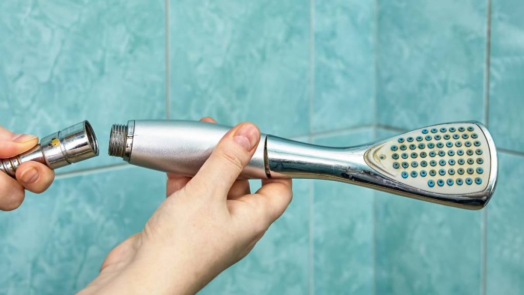 how to clean a shower head: Removing old rusted shower head in bathroom.