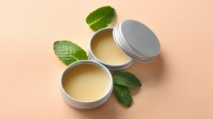 Containers with lemon balm salve and leaves