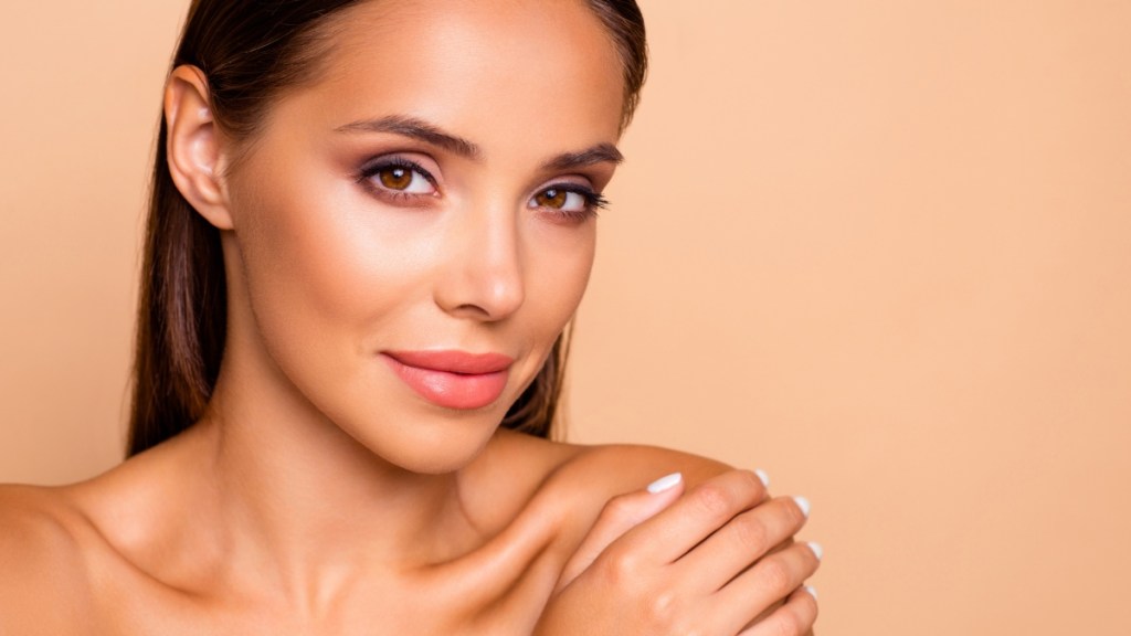 mature woman contouring face with self tanner