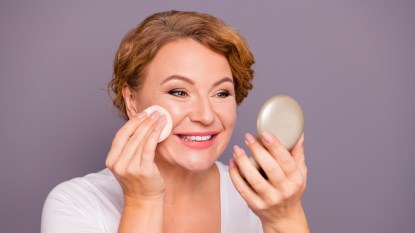 mature woman using setting powder and smiling