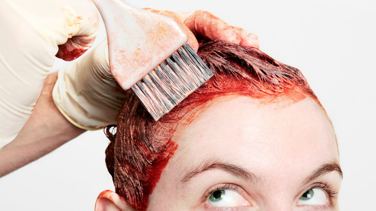 woman with red hair dye on her head and on her skin