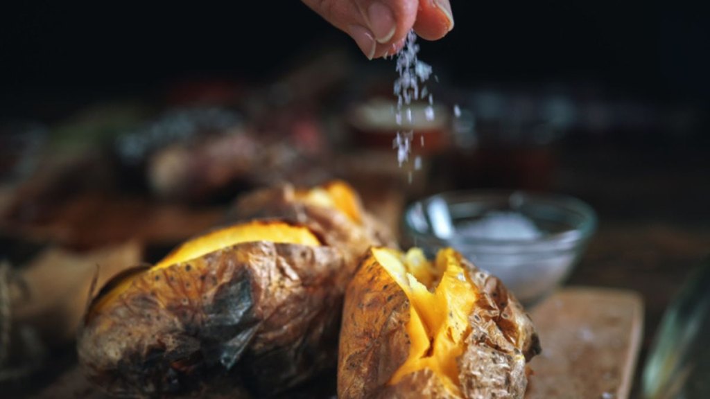 loaded baked potato salad: seasoning baked potatoes with salt