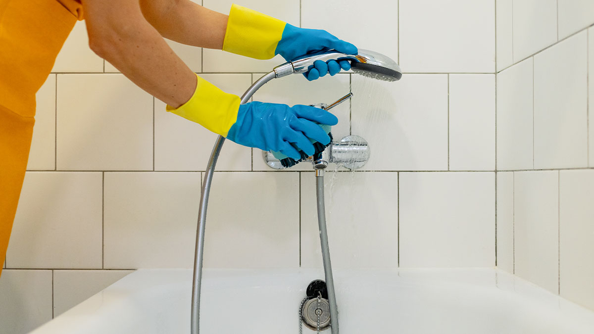 hand cleaning a shower head nozzle