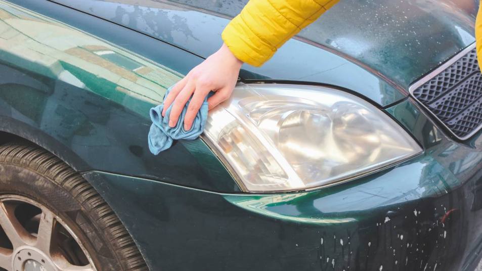 How to clean foggy headlights like this lady is doing with a blue rag.