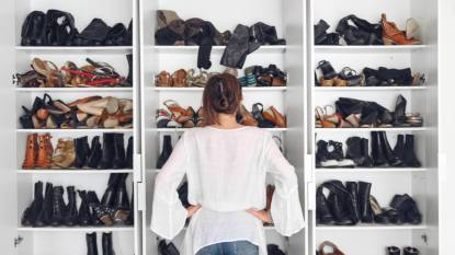 Woman standing in front of closet trying to figure out her shoe storage