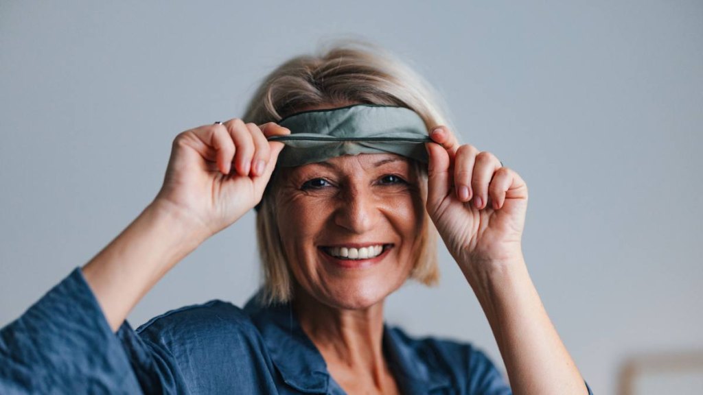 Mature woman putting on an eye mask to take a nap
