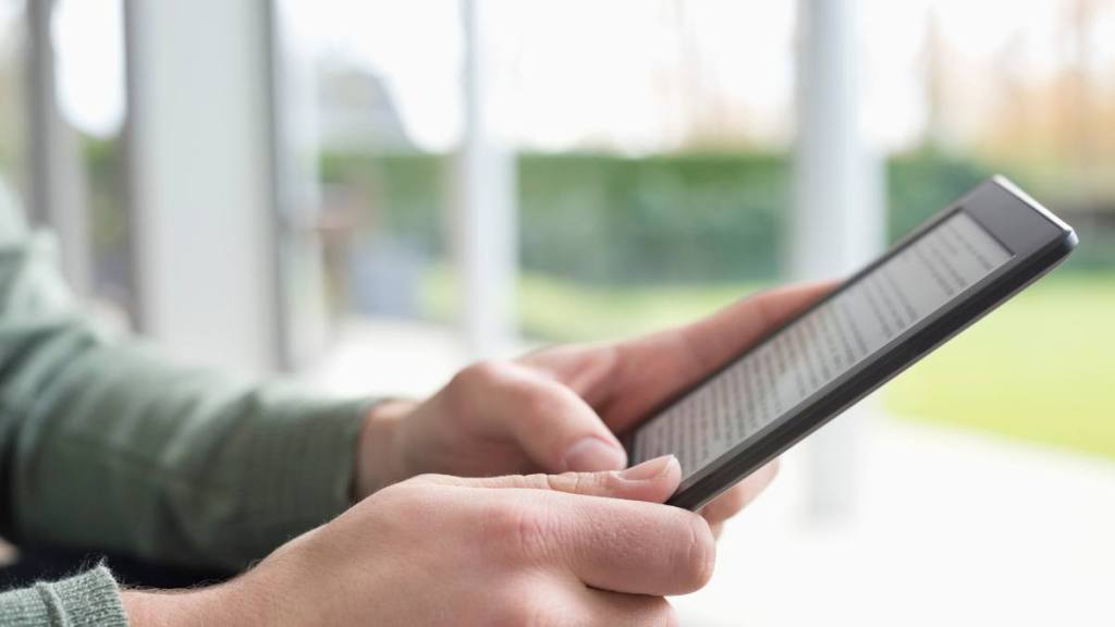 Person reading on a kindle to help read more books