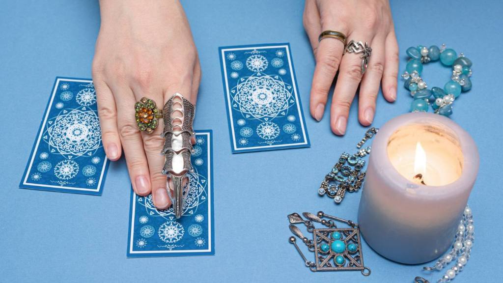 beginner tarot spread: Fortune teller holding a tarot cards in the hands.