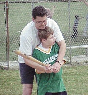 Dom helping with his son, Domenico swing a bat when he was a boy