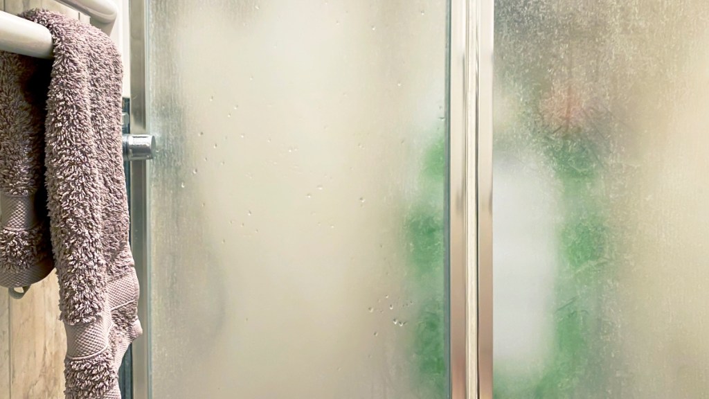 A cloudy shower door that can be cleaned with powerwash